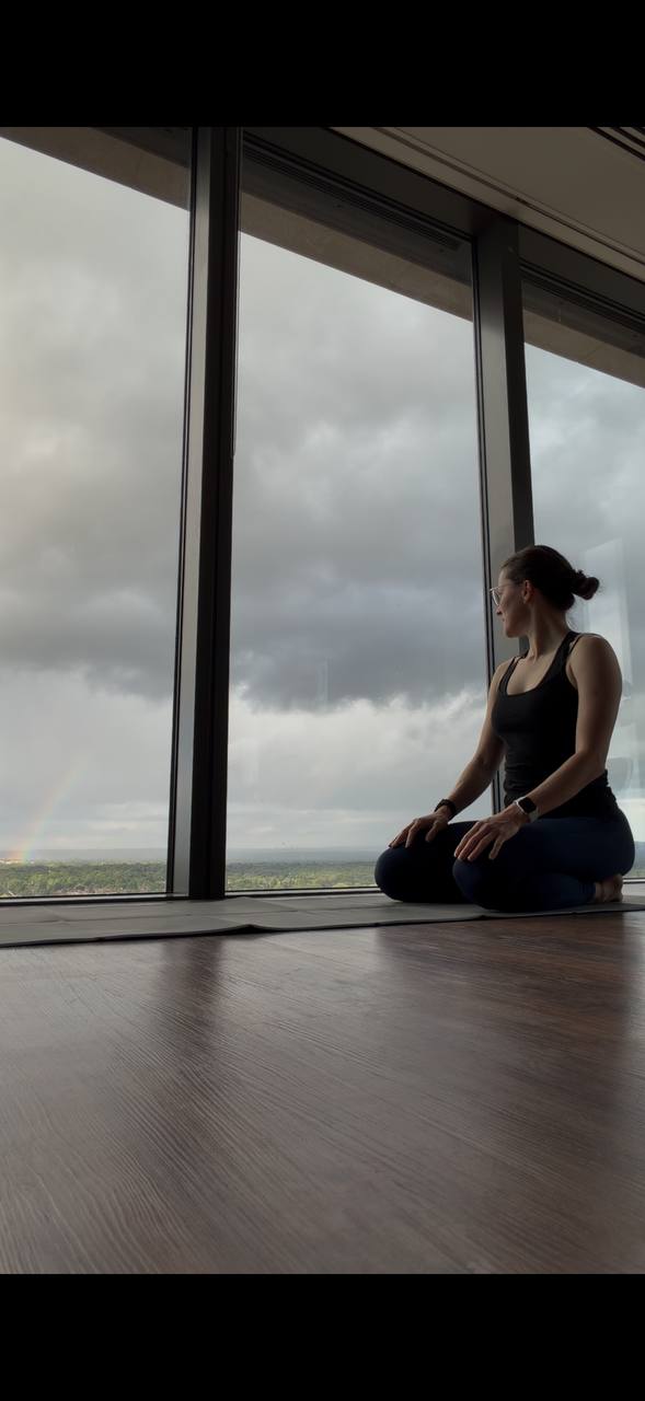 Yoga practitioner seated by large studio windows
