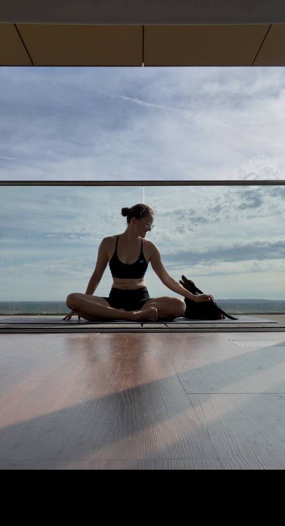 Olga seated with her dog by large studio windows
